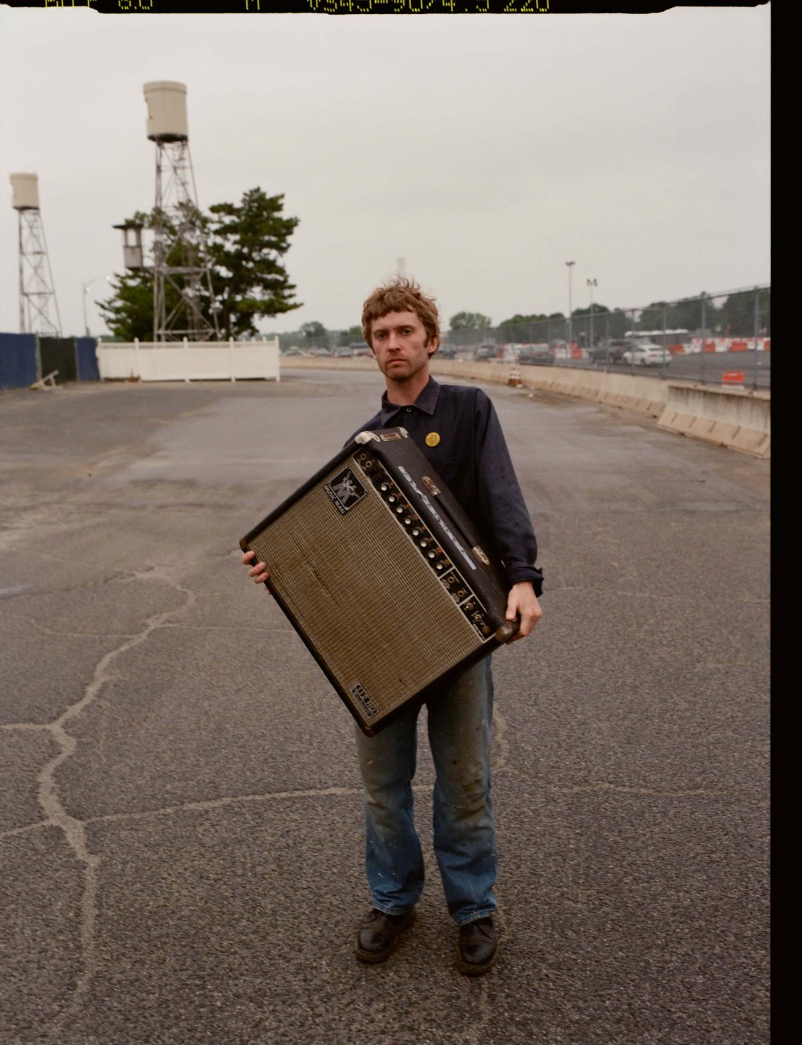 songwriter Greg Freeman holding an amplifier
